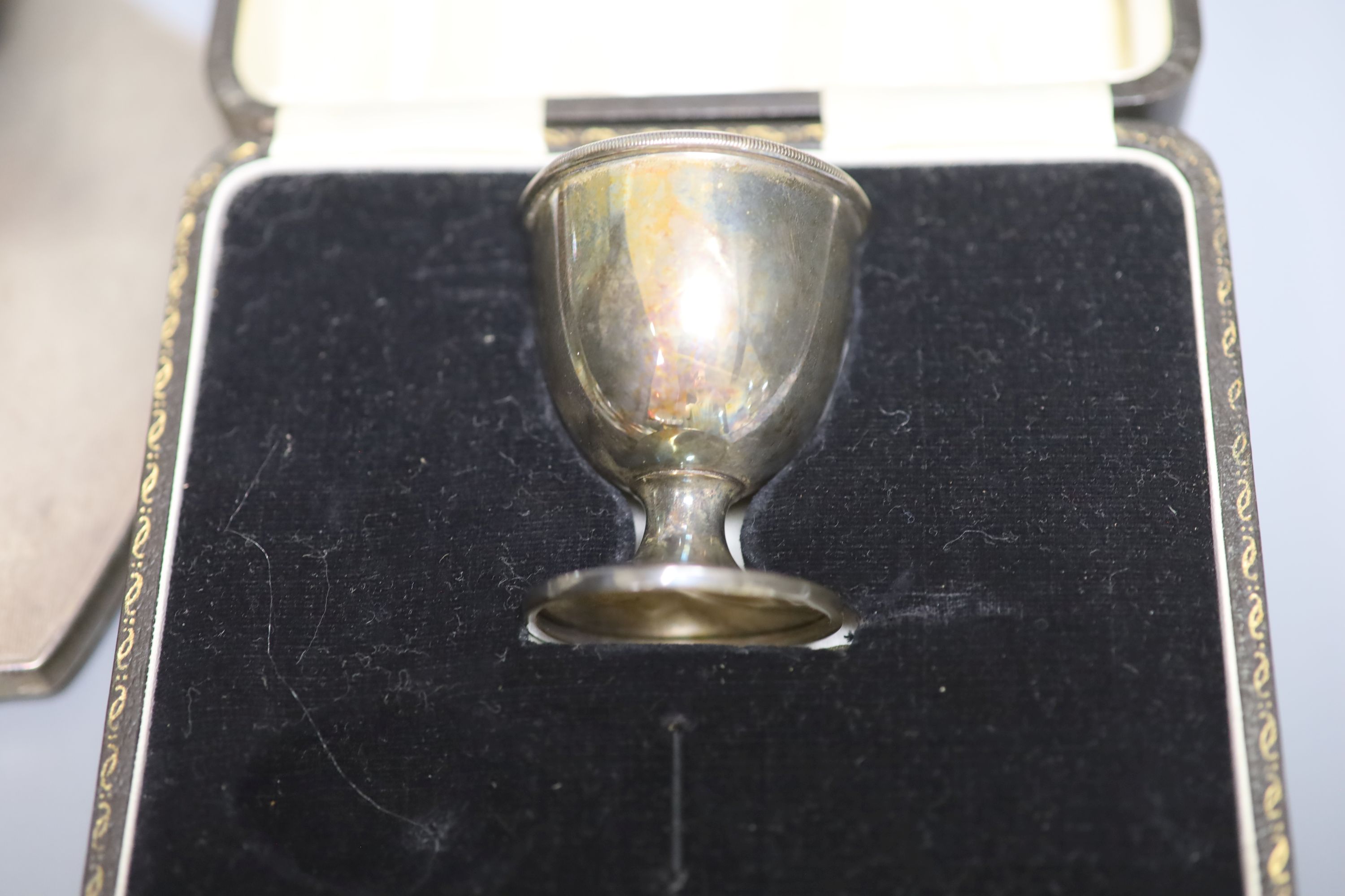 A George V Arts & Crafts silver baluster sugar caster, by Albert Edward Jones, 14.8cm, cased, a five-piece engine-turned dressing table set and two cased Christening sets